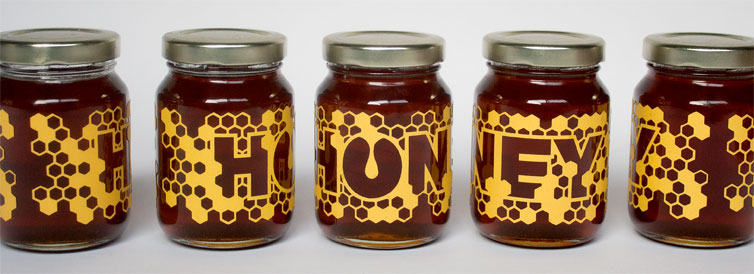 laser cut honey labels on small jars of honey, designed by Riley Raker