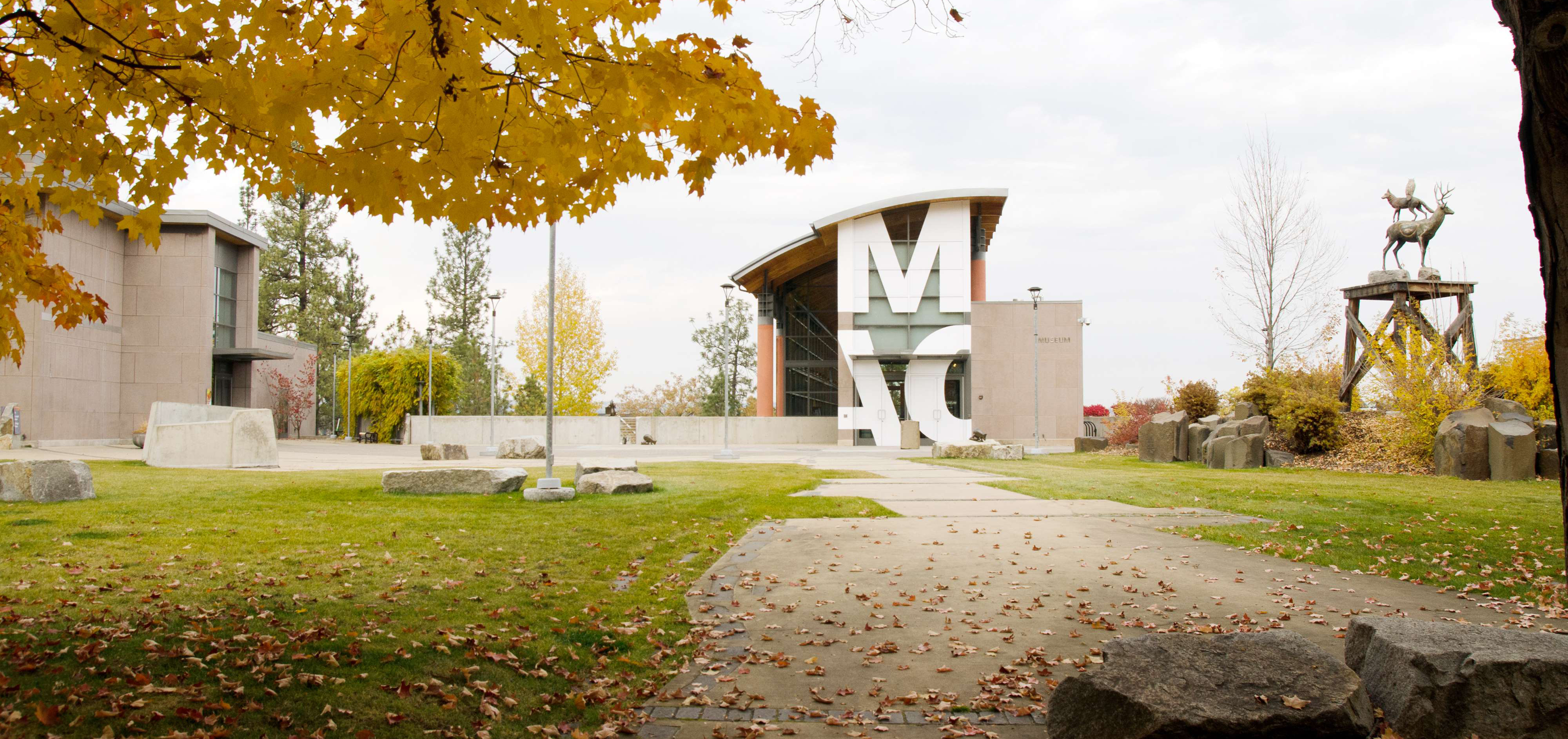 Logo applied to the exterior of the MAC Museum building on a fall day.