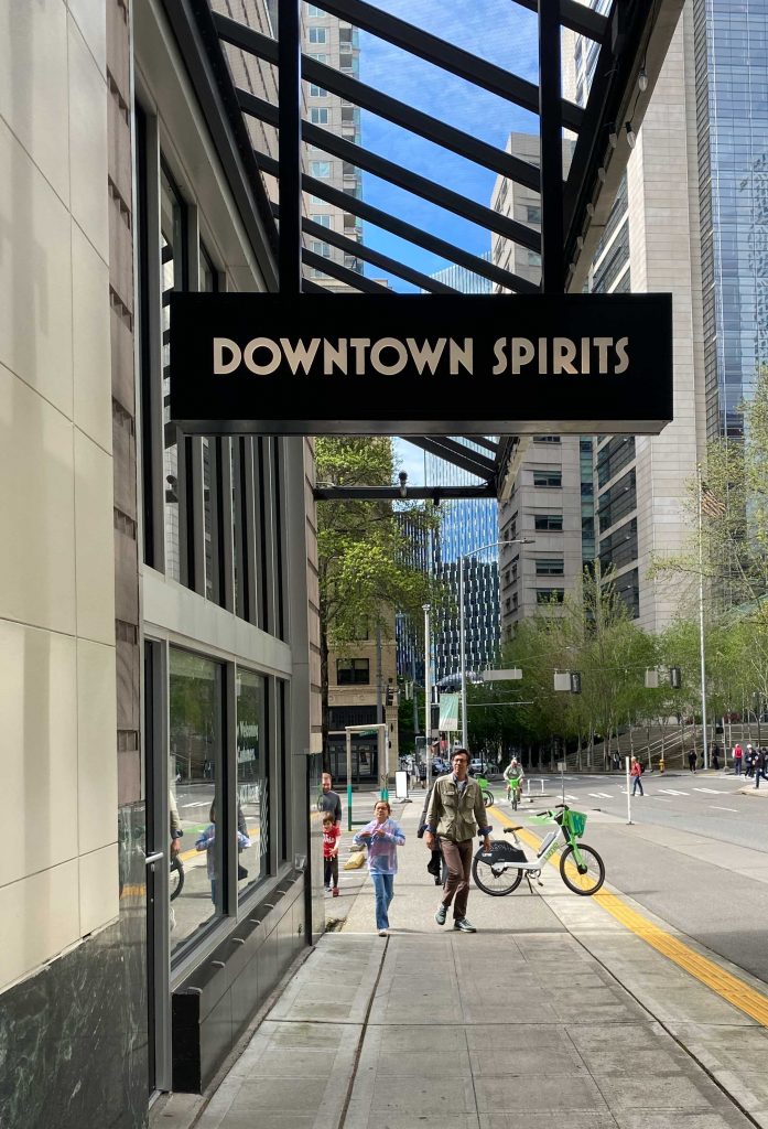 man and child walking in front on downtown spirits storefront 