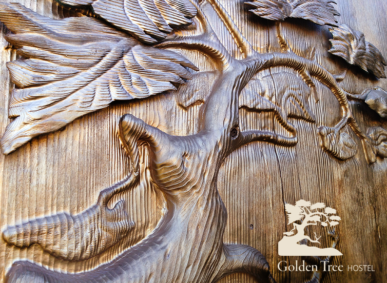 Golden wood carving of a tree that inspired the name and logo design of Golden Tree Hostel.